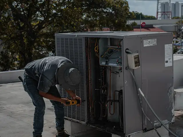 Technician checking an outdoor air conditioning condenser
