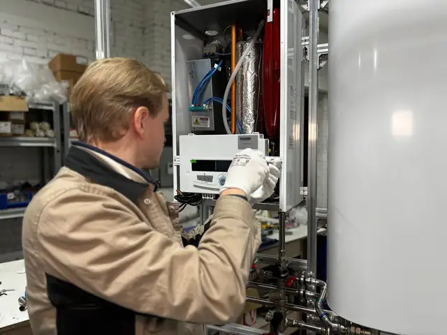Technician adjusting the controls of a home heating system