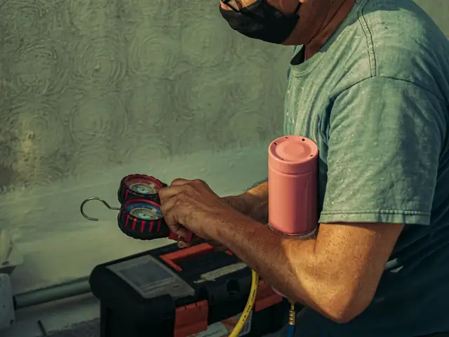 Technician checking refrigerant pressure during an HVAC tune-up